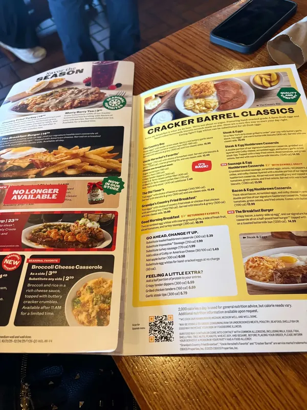 Menu spread with a Cracker Barrel Classics section on a yellow ground beside a red seasonal page, showing photographed entrees and a No Longer Available flag.