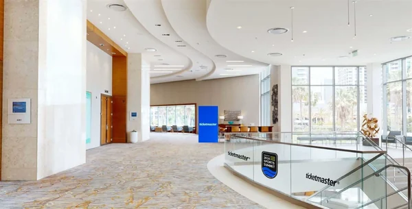 Glass-railed landing outside the ballroom, with blue Ticketmaster signage mounted on the wall.