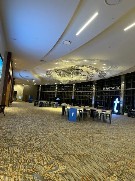 Ballroom set with high-top tables and black Ticketmaster banners along the wall, under a sculpted ceiling.