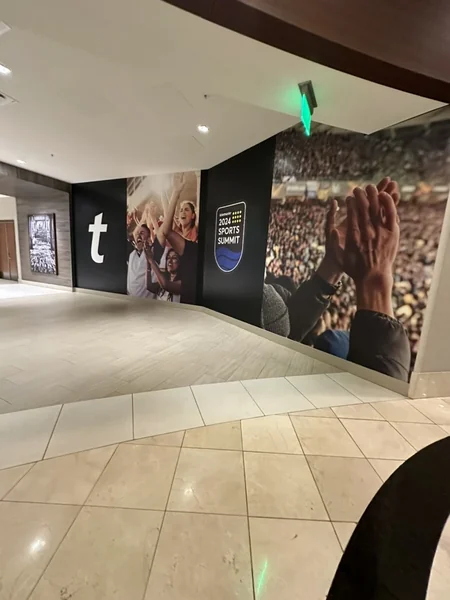 Entry hallway lined with a large black and white crowd photograph, with a tall black Ticketmaster banner at the end.