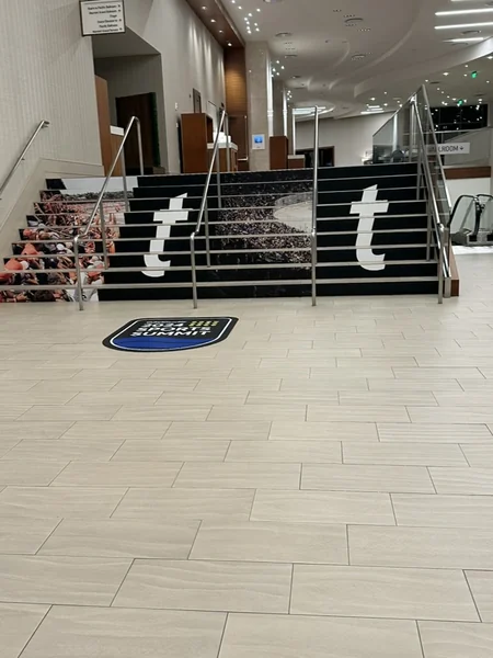Wide staircase into the venue with black Ticketmaster banners on either side and a branded floor decal at the base.